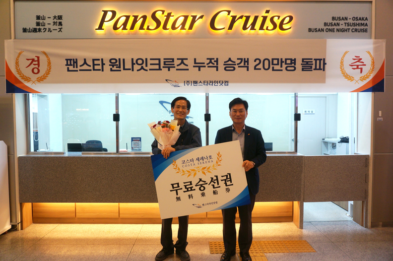 곽인섭(오른쪽) 팬스타라인닷컴 대표가 20만 번째 승객에게 무료승선권을 증정하고 있다. 사진 : 팬스타